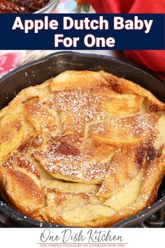 an apple dutch baby in a cast iron skillet with powdered sugar on top