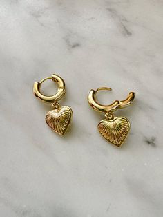 These gold plated hoop earrings feature a light weight gold plated heart charms. Hoops latch closed for a secure hold. Gold plated jewelry should be removed before swimming, bathing or working out. Gold Heart-shaped Huggie Earrings For Everyday, Everyday Gold Heart Huggie Earrings, Gold Single Heart Earring For Everyday Wear, Everyday Gold Heart-shaped Huggie Earrings, Everyday Gold Double Heart Huggie Earrings, Gold Plated Heart Huggie Earrings Tarnish Resistant, Gold Plated Heart Huggie Earrings, Gold Plated Heart Charm Drop Earrings, Gold Plated Heart-shaped Tarnish Resistant Huggie Earrings