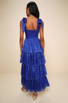 the back of a woman wearing a blue dress