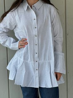 Made from 100% cotton, the Brynlee Ruffle Tunic Shirt is perfect for any season. Its lightweight material and cuffed sleeves provide both comfort and style. The versatile design features a ruffle bottom and can be worn open or closed with buttons down the front. Elevate your wardrobe with this striped must-have! Measurements S: bust 40" length 29" shoulders 15" M: bust 44" length 31" shoulders 16" L: bust 48" length 33" shoulders 17" Cotton Button-up Blouse With Smocked Cuffs, Cotton Shirt For Spring Daywear, Cotton Button-up Top With Smocked Cuffs, Summer Button-up Tops With Smocked Cuffs, Trendy Cotton Tops With Smocked Cuffs, Spring Long Sleeve Tops With Ruffle Hem, Spring Cotton Blouse With Ruffle Sleeves, Chic Cotton Top With Smocked Cuffs, Ruffled Long Sleeve Relaxed Fit Blouse