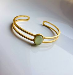 A piece of stylish & modern look gold bangle, which is made with genuine 100% natural real light green Chinese jade bead and 14k gold plated 925 sterling silver bracelet. A great combination of charm and elegance. The minimalistic design is great for your daily wear or special occasions. Perfect as a gift for your loved ones or just as a treat yourself :) Some Highlights of this gold jade bead cuff are: ＊High-quality Material Only 100% natural green jades paired with solid 925 sterling silve Elegant Adjustable Jade Jewelry, Gold Jade Bangle Bracelet, Modern Green Cuff Bangle Bracelet, Modern Green Gemstone Bracelets, Elegant Jade Bracelets For May Birthstone, Modern Yellow Gold Jade Jewelry, Modern Oval Jade Jewelry, Modern Jade Gemstone Jewelry, Elegant Jade Bracelet For May Birthstone