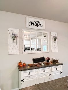 a kitchen with white cabinets and black counter tops, decorated with pumpkins and flowers