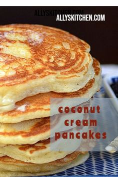 a stack of pancakes sitting on top of a blue and white plate with the words coconut cream pancakes