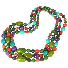 Hattie Carnegie multi strand bakelite and resin bead necklace. The three strands comprised of marbleized avocado, coral, turquoise,and purple vari size beads with gilded metal spacers. Signature rectangular peridot crystal clasp. 1950's USA. Signed. Excellent Condition. Length 28" longest strand Length 22" shorest strand Width at bottom 3" Jellyfish Jewelry, Hattie Carnegie, Branch Earrings, Peridot Crystal, Vintage Beads Necklace, Sparkly Jewelry, Ocean Jewelry, Citrine Necklace, Turquoise And Purple