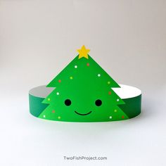 a green paper christmas tree hat with gold stars on it's head and eyes