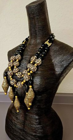 Unworn and from my private vault; needs a new home! This extremely rich, posh, elegant and dramatic beaded chest piece will make you feel rich even if you're slightly less than. Huge leopard and ornate Tibetan brass repousse bicones are the stars in this OOAK statement necklace - chest piece. The leopard beads are separated with shiny gold tone metal balls and rhinestone rondelles. Five beaded dangles are suspended from the outer most strand consisting of the gold metal balls, the huge Tibetan brass repousse beads and twisted black onyx beads. 20 mm round black onyx defines the mid section along with ornate gold tone metal strand separators on both sides. The back is finished with twisted black onyx and faceted crystals. Adjusts from 26-29" with gold tone hardware, an xl fancy lobster claw Luxury Beaded Necklaces With Round Beads, Luxury Black Beaded Necklaces, Black Bohemian Necklace For Ceremonial Occasion, Artisan Black Ceremonial Jewelry, Elegant Black Ceremonial Necklace, Luxury Handmade Ceremonial Necklaces, Artisan Gold Jewelry With Black Beads, Artisan Gold Necklace With Black Beads, Luxury Handmade Ceremonial Necklace