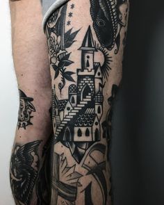 a man's arm with tattoos on it and an image of a castle in the background