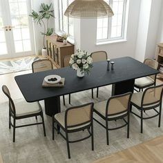 a dining room table and chairs in front of a window