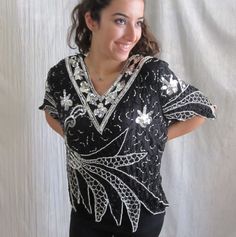 "Straight from the era of disco, this fab little top has so much going on. All over sequins and beads in black and silver. Check out the zig zag design at the bottom and sleeves. 100% silk. Made in India. EXCELLENT vintage condition with no spots, holes or other defects. All sequins appear to be intact. As with all pre-owned clothing, this should be laundered prior to wearing. FITS SIZE M-L Please review the measurements below for an accurate fit. All measurements are taken with the garment laid Black Party Top With Contrast Sequin, Vintage V-neck Party Blouse, Vintage V-neck Blouse For Party, Black Party Tops With Contrast Sequin, Disco Style Embellished Evening Tops, Disco Style Embellished Tops For Evening, Disco Style Top For Evening Party Season, Embellished V-neck Party Top, Embellished V-neck Top For Party