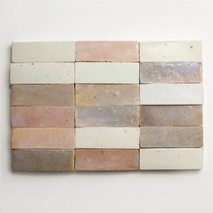 a white wall with several different colored tiles on it