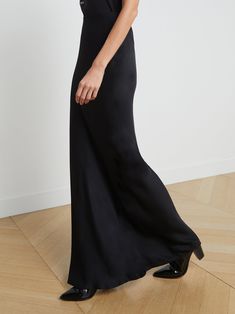 A stunning, understated maxi skirt in pure black. Bias-cut, silk-like fabric falls in a subtle, lustrous cling over the figure, enhancing and elongating the silhouette. Smooth elastic waist with no closures. | L'AGENCE Zeta Maxi Skirt In Black Full Length Satin Finish Maxi Dress, Sleek Full-length Bias-cut Maxi Dress, Sleek Flared Maxi Skirt For Evening, Chic Full-length Silk Maxi Skirt, Chic Full Length Silk Maxi Skirt, Sleek Relaxed Maxi Skirt, Silk Maxi Skirt With Bias Cut, Flowy Wide Leg Skirt With Bias Cut, Fitted Satin Finish Maxi Skirt