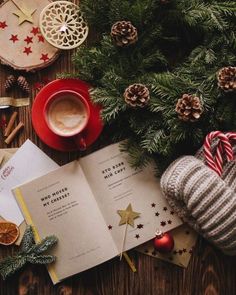 an open book sitting on top of a table next to christmas decorations and other items