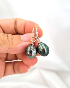 Tahitian pearl earrings that you have to have for your jewelry box. Both versatile and timeless, they will quickly become your go-to-earrings for everyday and special occasions.  Thoughtful gift to treat yourself or as a special gift that will be loved and cherished. All Glitz & Love jewelry are beautifully gift wrapped and ready for gift giving. ♡ Sea Pearl Type: Tahitian Pearl ♡  ✧ Tahitian Pearl size: Approx 9.6mm x 12.1mm, 10.6mm x 11.7mm. ✧ Natural Pearl Color: Green with purple / blue shee Tahitian Pearl Drop Earrings Gift, Tahitian Pearl Jewelry With Matching Earrings For Gift, Tahitian Pearl Jewelry With Matching Earrings For Anniversary, Tahitian Pearl Jewelry Set With Matching Earrings For Gift, Tahitian Pearl Dangle Earrings Gift, Anniversary Tahitian Pearl Drop Earrings, Silver Tahitian Pearl Drop Earrings, Tahitian Pearl Teardrop Jewelry For Formal Occasions, Tahitian Pearl Drop Pear-shaped Jewelry