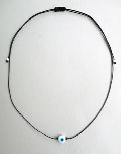 Evil eye necklace White and Turquoise eye bead Black string choker Mens evil eye Evil eye jewelry Protection amulet Minimalist Gift Simple This simple yet beautiful choker necklace is made using durable black waxed string and has a white glass bead evil eye in the middle,and seed beads at the ends. The diameter of the flat eye bead is 8mm approx. It is adjustable with a sliding knot closure. More string bracelets in my shop: https://www.etsy.com/shop/LuckyRatJewellery?ref=seller-platform-mcnav&a Adjustable Round Evil Eye Necklace, Adjustable Evil Eye Amulet Necklace, Adjustable Evil Eye Spiritual Necklace, Adjustable Spiritual Evil Eye Necklace, Adjustable Evil Eye Round Pendant Necklace, Adjustable Evil Eye Choker Necklace, Adjustable Evil Eye Choker, Adjustable Evil Eye Choker Jewelry, Minimalist Adjustable Single Strand Choker