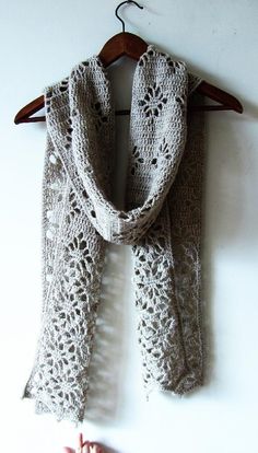 a white scarf hanging on a wooden hanger