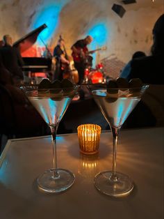 two martini glasses sitting on top of a table