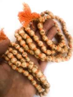 Neem japa mala made from Neem beads, hand knotted on orange cotton thread, and printed in Hindi script with "Radhe Radhe" on each bead. (Printing is not so great; barely legible in some cases, but the thought is there!) The beads are approximately 8mm or 10mm (two sizes) and end with small orange-colored cotton tassel. Choose from two sizes small 7- 8mm beads ($4.50) large 9 - 10mm ($5.50) Spiritual Wooden Beads Mala For Festival, Bohemian Hand-strung Orange Beads, Traditional Orange Beads For Gifts, Hand-strung Orange Bohemian Beads, Holistic Wooden Beads Mala For Festivals, Orange Wooden Beads For Festivals, Hand-strung Orange Beads As A Gift, Orange Wooden Beads For Festival, Bohemian Mala With Wooden Beads For Festivals