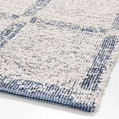 a blue and white rug on a white floor with an area rug in the middle