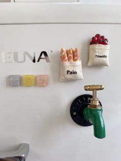 a refrigerator with magnets on the wall and various items hanging from it's handles