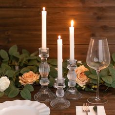 a table with candles, plates and glasses on it