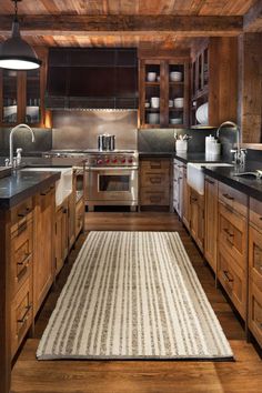 a kitchen with wooden cabinets and an area rug