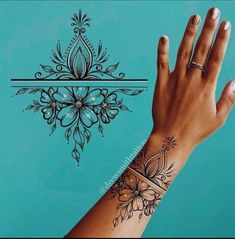 a woman's hand with a tattoo on it and an ornamental design behind her