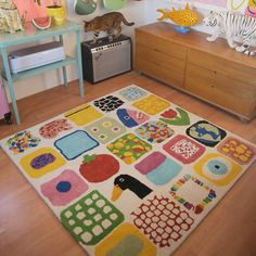 a colorful rug is in the middle of a room with toys and other items on the wall