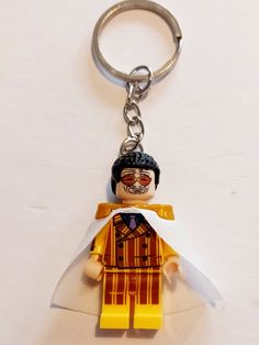 a lego keychain with a man holding a piece of paper