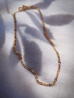 A classic luminescent gold anklet made from 18kt gold filled. The Nanea anklet is a stunning addition to your collection. The lines of this piece are elegant, shimmery, and the perfect dainty adornment for summer days. ✦ DETAILS ✦✧ Name: Nanea - (nah neh ah) - fascinating.✧ Adjustable Length up to 10" inches.✧ 18kt Gold Filled.✧ You will receive 1 anklet.✧ All Ke Aloha Jewelry pieces come packaged thoughtfully, beautifully, and ready for gift giving. Gold Delicate Anklet For Gift, Delicate Gold Anklets As Gift, Delicate Gold Anklet For Gift, Dainty Gold Bracelet With Figaro Chain, Dainty Gold Figaro Chain Bracelet, Gold Chain Anklets As Gift, Gold Chain Anklet Gift, Delicate Yellow Gold Anklet For Gift, Delicate Yellow Gold Anklet As Gift