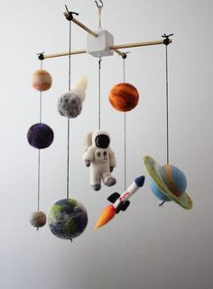 a mobile made to look like an astronaut's space shuttle with planets hanging from it