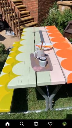 a picnic table painted with an orange and yellow design