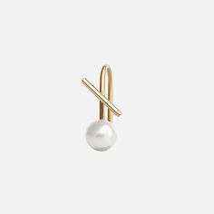 a pearl and gold pin on a white background