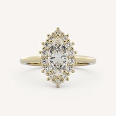 a yellow gold engagement ring with an oval cut diamond surrounded by small round brilliant diamonds