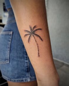 a small palm tree tattoo on the arm