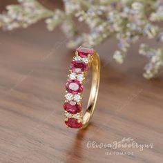 a close up of a ring on a wooden surface with flowers in the back ground