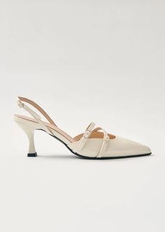 Pointed-toe slingback pumps crafted from cream leather with slender heels and slim buckled straps lying across the vamps | Enjoy up to 30% off when you shop on demand at ALOHAS.