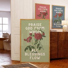 three framed posters on the wall in a room with wood flooring and wooden furniture