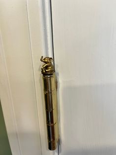 an old brass door handle on a white door