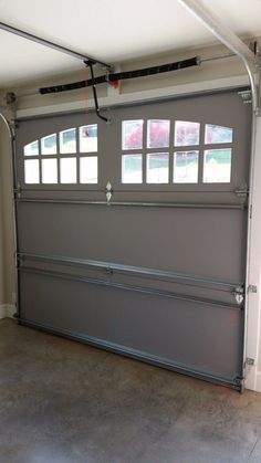 an overhead garage door with windows in the middle and two bars on each side that lead into a parking lot