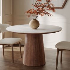 a round table with two chairs and a vase on top