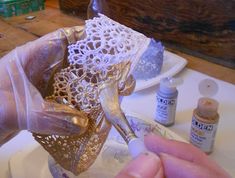 a person is making something with lace on the edge of a plate and some glue