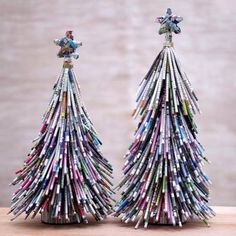 two small christmas trees made out of newspapers