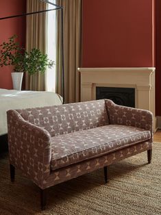 a living area with a bed, couch and fireplace in it's centerpiece