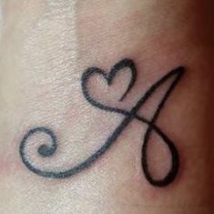 a tattoo on the wrist that has a heart and letter k in it's center