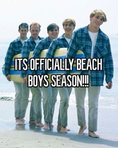 a group of young men standing next to each other on top of a sandy beach