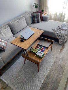 a living room with a gray couch and wooden coffee table