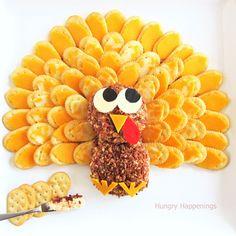 a turkey made out of crackers sitting on top of a white plate next to some crackers