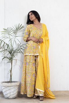 This mul-mul hand block print sharara set is a comfort wear this summer embellished with gota work and mul dupatta. Designer Yellow Palazzo Set With Printed Motifs, Yellow Bohemian Palazzo Set With Printed Motifs, Bohemian Yellow Palazzo Set With Printed Motifs, Bohemian Chanderi Palazzo Set For Eid, Summer Designer Pant Set With Dupatta, Bohemian Chanderi Sharara For Eid, Yellow Palazzo Set With Straight Kurta And Gota Work, Yellow Palazzo Set With Gota Work And Straight Kurta, Bohemian Palazzo Set With Straight Kurta And Dupatta