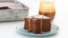 a piece of chocolate cake on a blue plate with caramel syrup in the background