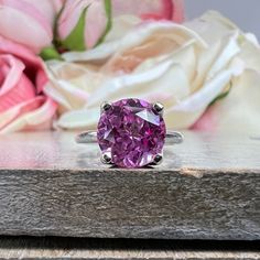 "This ring pictured is lab created pink sapphire #6465 -Approximate total carat weight: 2.70ctw. diamond equivalent -Center Stone Size: 9mm - approx. 2.70ct diamond equivalent -Center Stone Shape: Round -Gem Type: Lab Created Sapphire -Stone Clarity: VS2 -Stone Color: Medium Pink -Moh's Scale: 9 hardness -Metal Type and Purity: 14k White or Yellow Gold -Setting: Tulip 4 Prong Setting -Stock Ring Size: 6 -Country of Manufacturing: USA (Michigan) For customization please contact us. If you have an Purple Pink Sapphire Promise Ring, Purple Pink Sapphire Ring With Center Stone, Pink Sapphire Ring With Center Stone In Sterling Silver, Classic Pink Ruby Ring With Brilliant Cut, Pink Sapphire Ring With Sterling Silver, Pink Cubic Zirconia Classic Ruby Ring, Pink Amethyst Ring In Sterling Silver For Anniversary, Gift Purple Pink Sapphire Ring, Pink Ruby Ring With Prong Setting In Cubic Zirconia